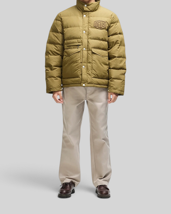 Baffle Haus Carson olive down jacket with chest branding, flap pockets, and zip front closure on a male model