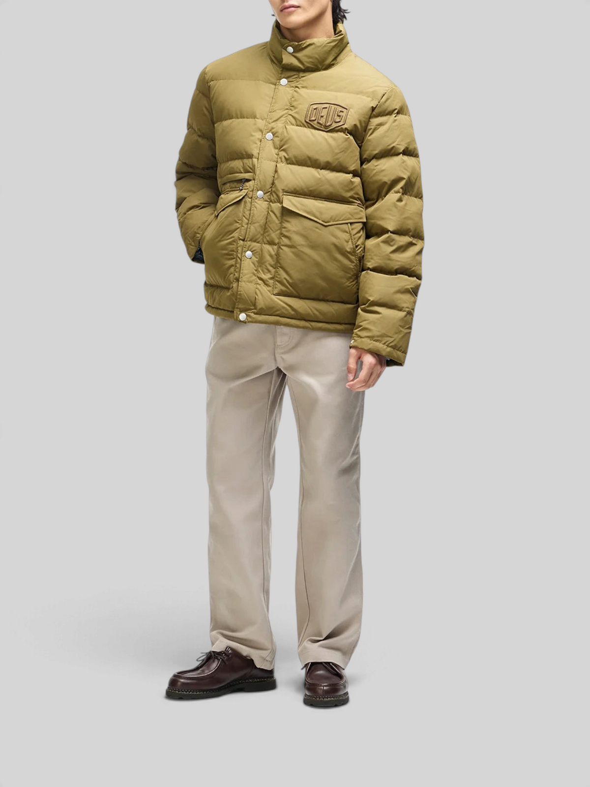 Baffle Haus Carson olive down jacket with high density chest branding, flap pockets, and snap placket on a model
