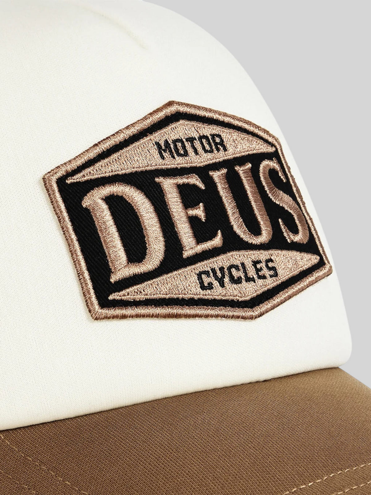 Baffle Haus Josel trucker cap in camel brown and white with an embroidered Deus Motor Cycles badge on the front