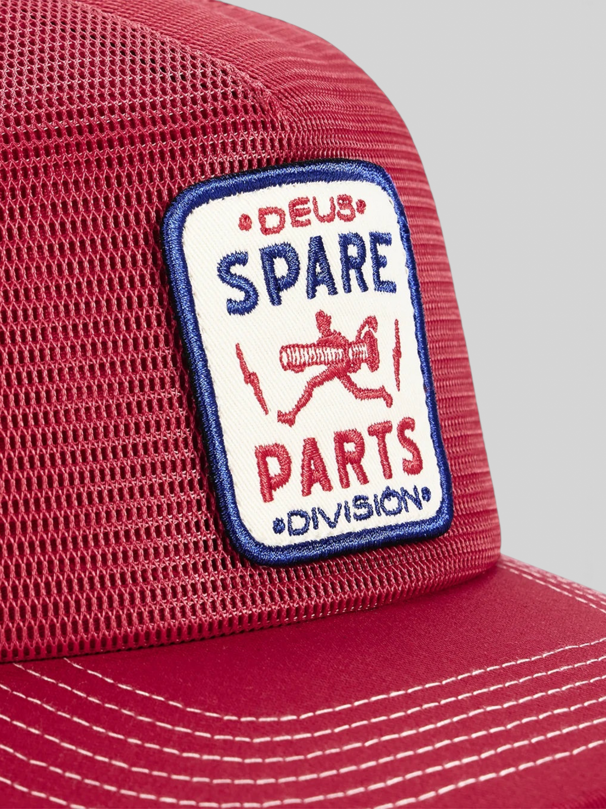 Baffle Haus Mudflap Trucker cap in cherry red with a detailed embroidered Spare Parts badge on the front mesh panel.