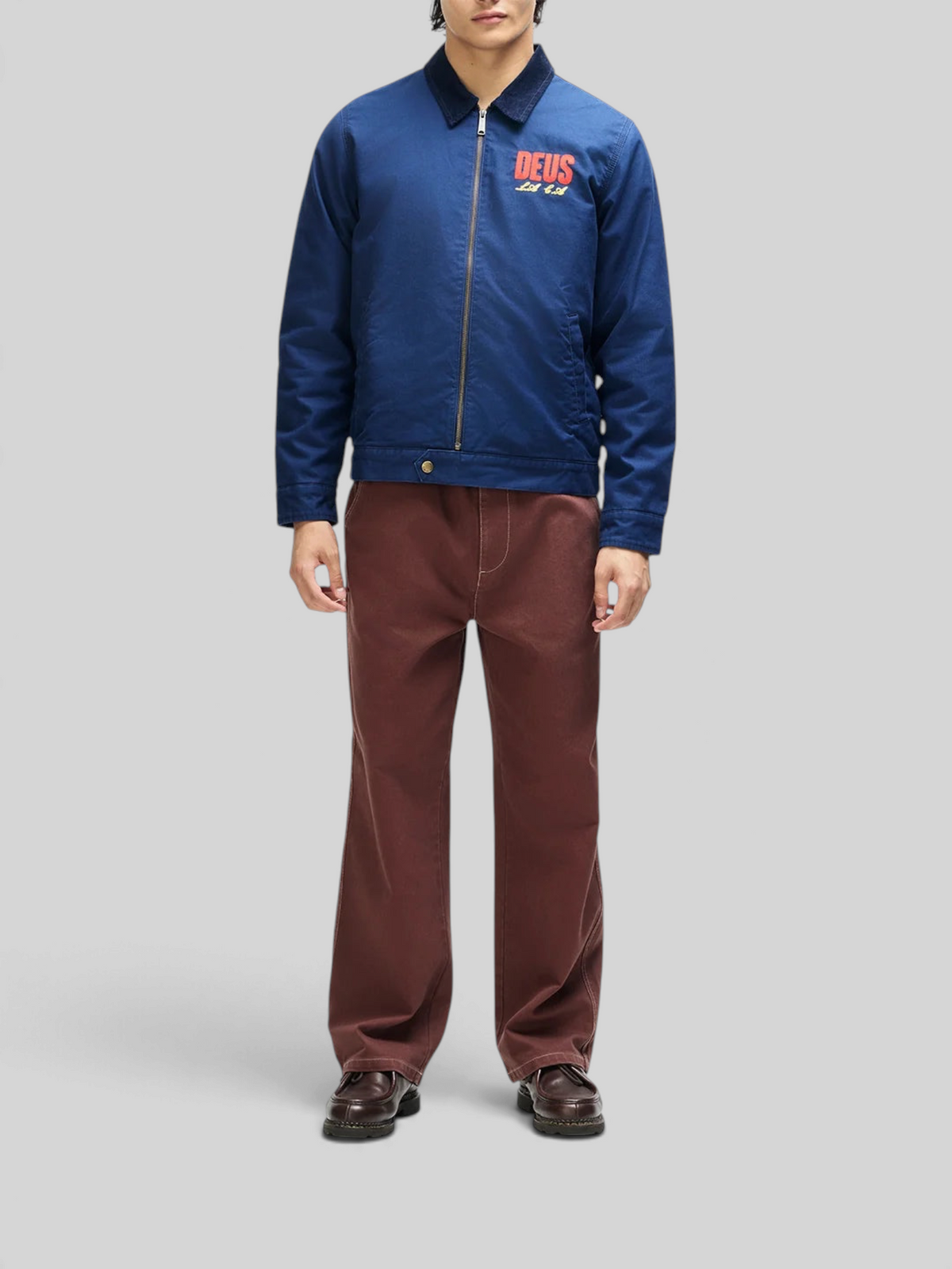 Baffle Haus navy cotton whipcord cutaway jacket with chest embroidery, zip front, and corduroy collar on a model