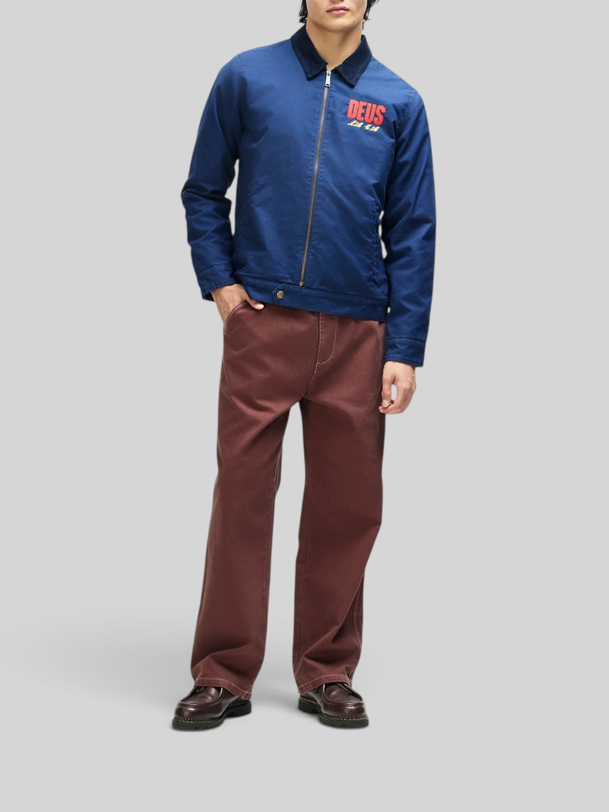 Baffle Haus navy cotton whipcord cutaway jacket with chest embroidery, zip front, and corduroy collar on a model