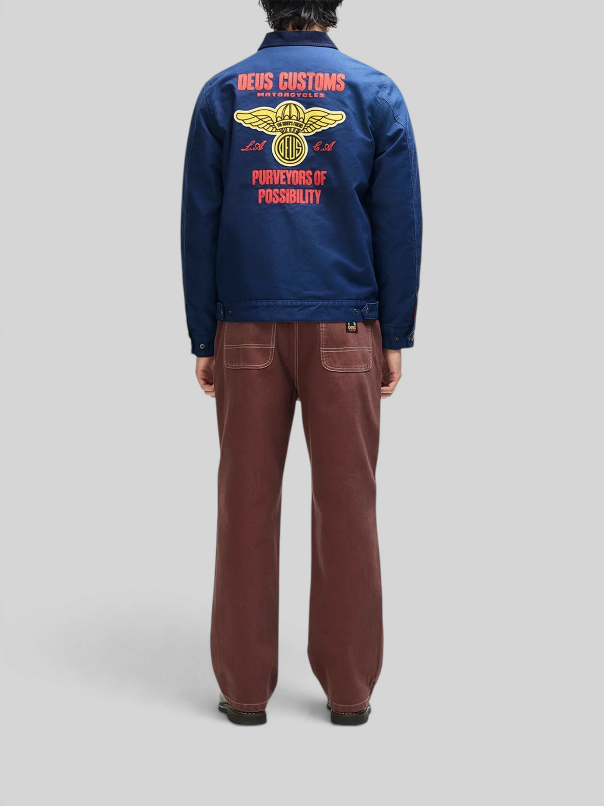 Baffle Haus navy cotton whipcord jacket with embroidered graphic art on the back, worn by a model from behind.