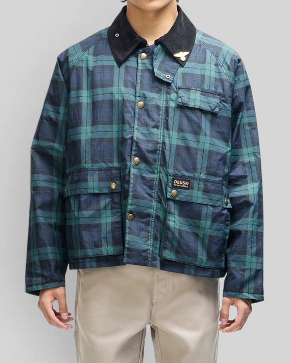 Baffle Haus Marsden hunting jacket in green check with a black corduroy collar, front pockets, and metal snap buttons.