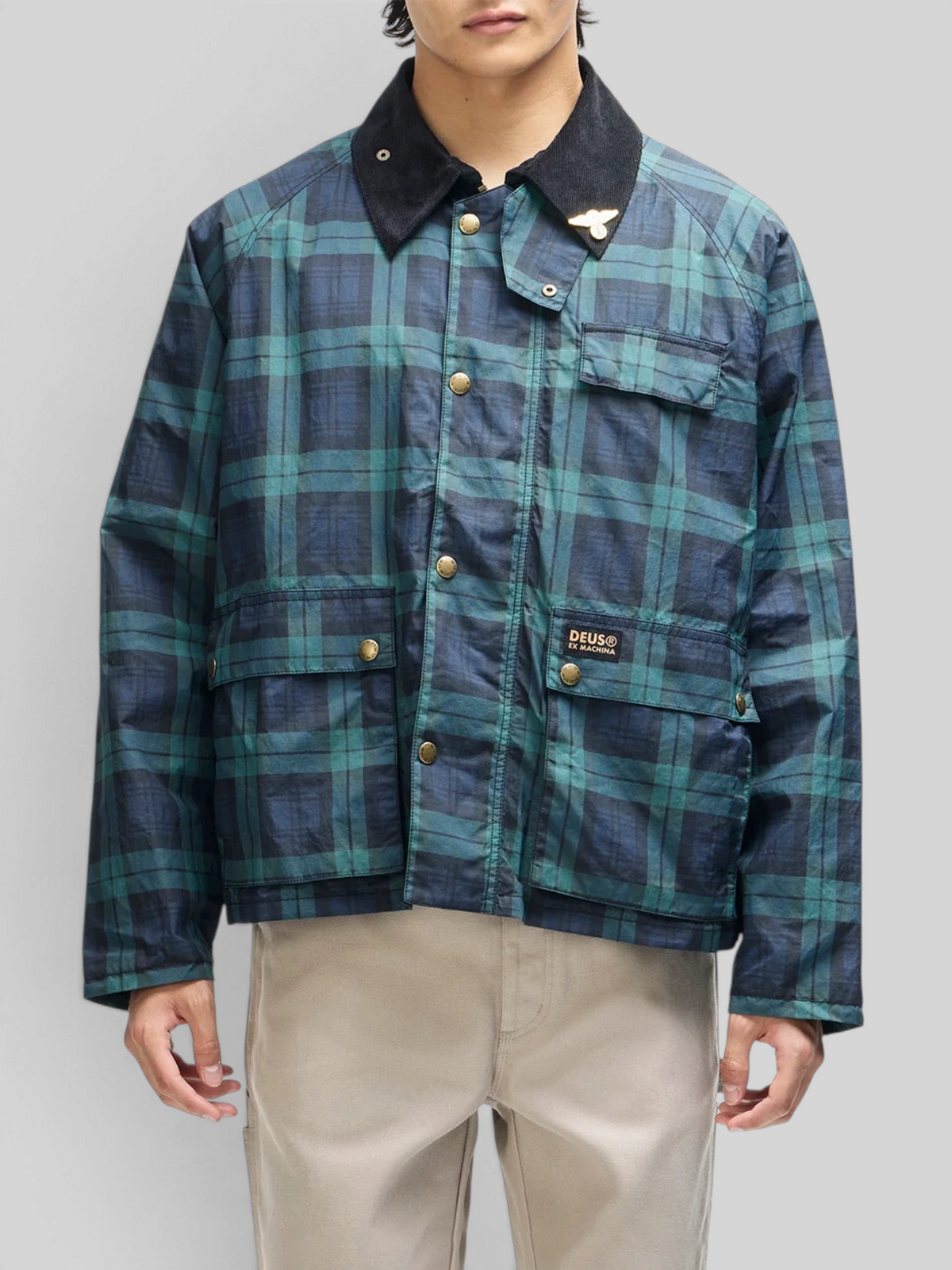 Baffle Haus Marsden hunting jacket in green check with a black corduroy collar, front pockets, and metal snap buttons.
