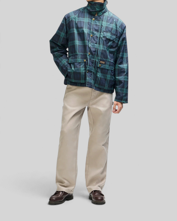 Baffle Haus Marsden hunting jacket in green check with corduroy collar, front pockets, and boxy fit on a model
