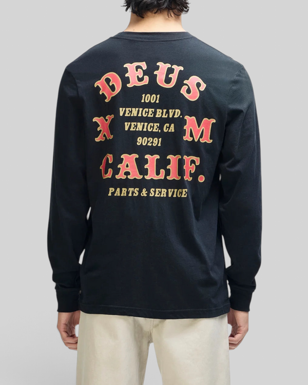 Baffle Haus black long sleeve tee with vintage-style red and yellow graphic print on the back, worn by a man.