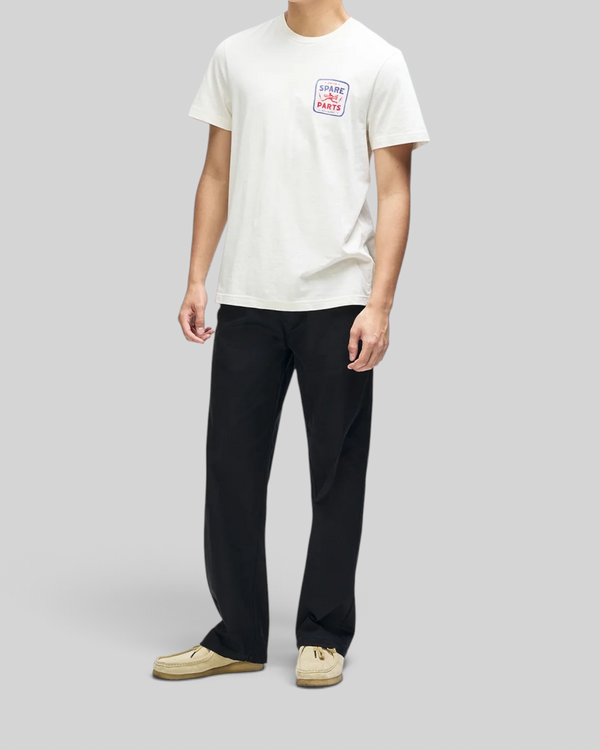 Baffle Haus Mudflap Tee in vintage white organic cotton with a boxy fit and chest graphic print on a male model