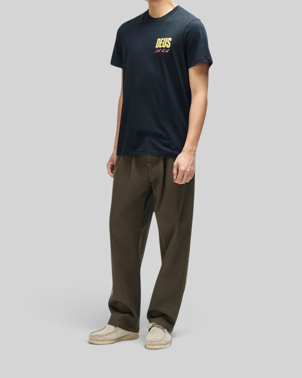 Baffle Haus black box fit organic cotton tee with yellow chest graphic worn by a model with olive trousers