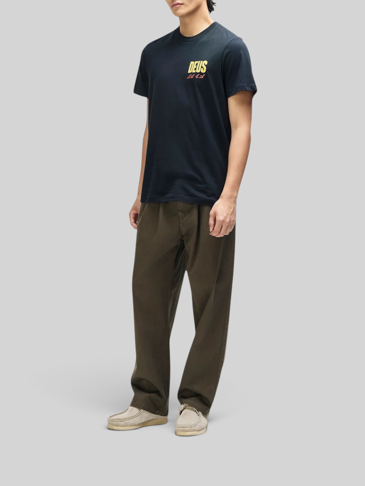 Baffle Haus black box fit organic cotton tee with yellow chest graphic worn by a model with olive trousers