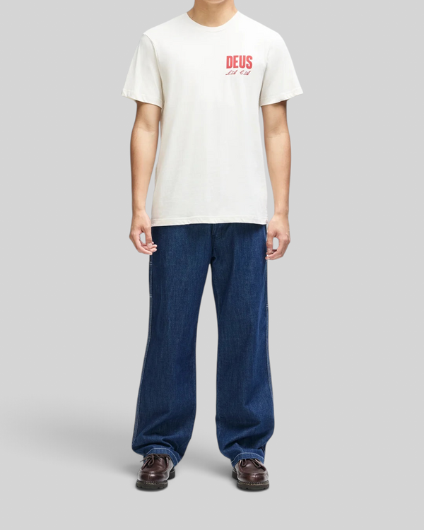 Baffle Haus vintage white box fit organic cotton t-shirt with red chest graphic worn by a model in blue jeans