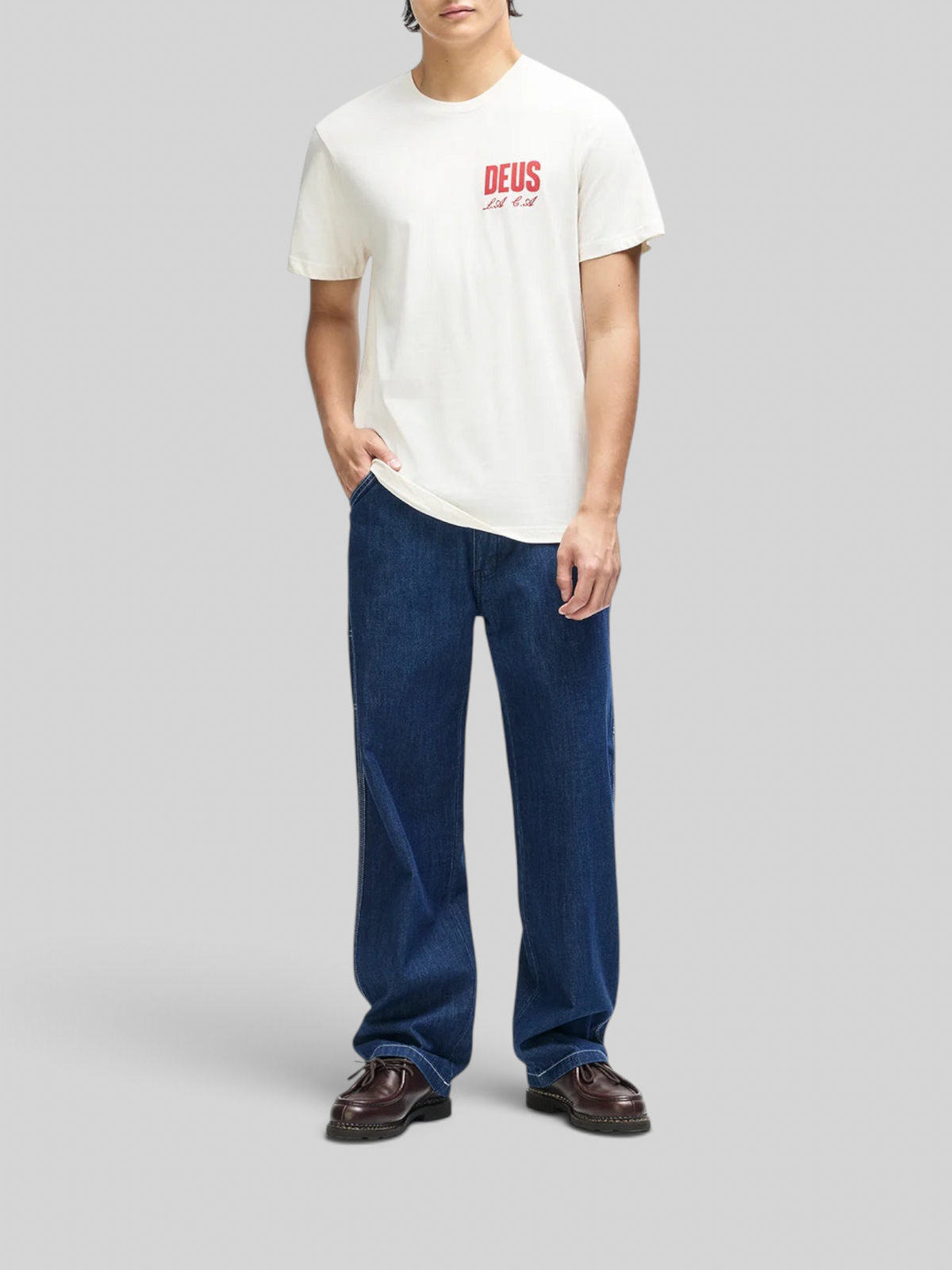 Baffle Haus vintage white box fit organic cotton tee with red chest graphic worn by a man with blue jeans
