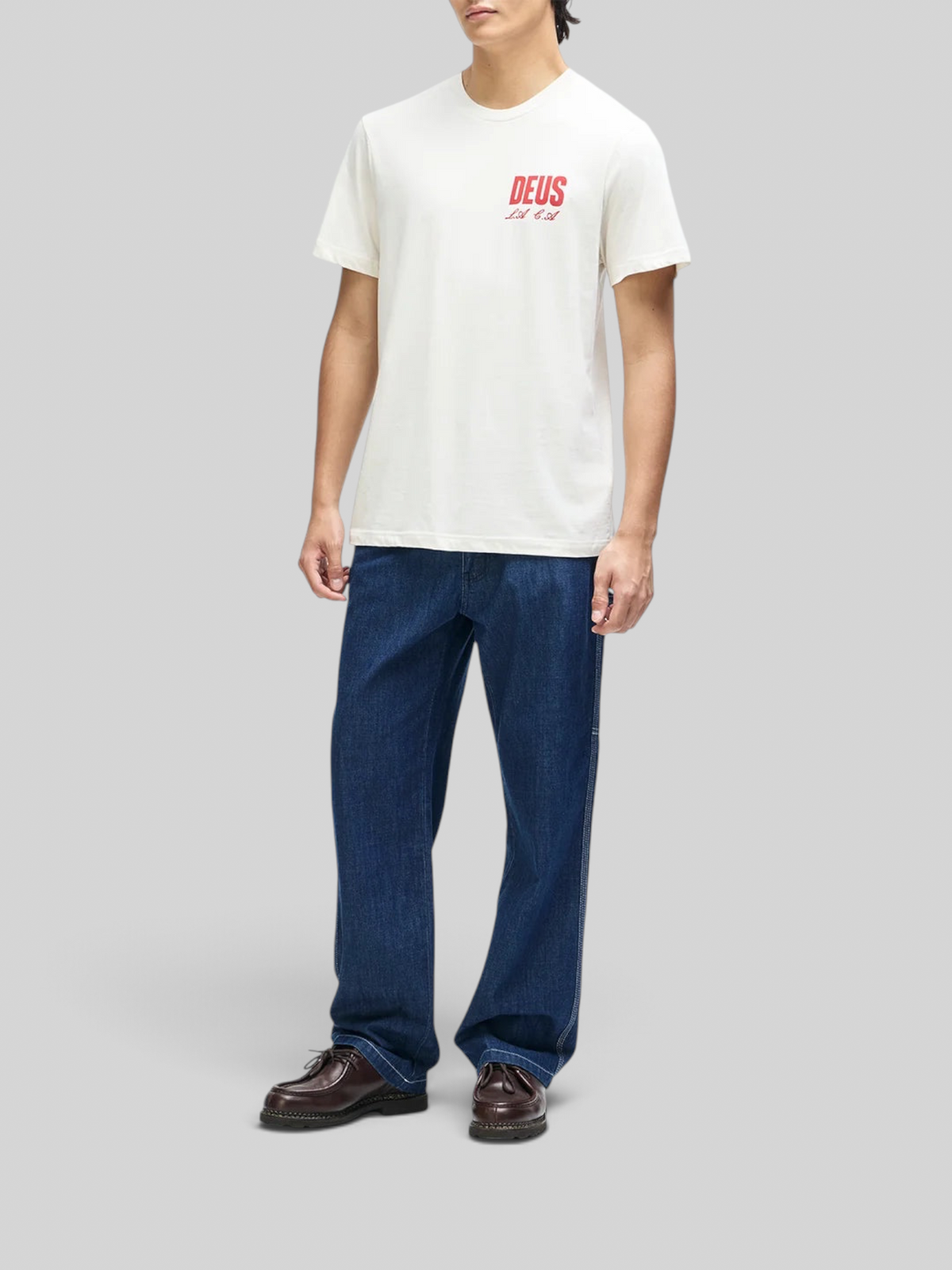 Baffle Haus vintage white box fit organic cotton t-shirt with red chest graphic worn by a man with blue jeans