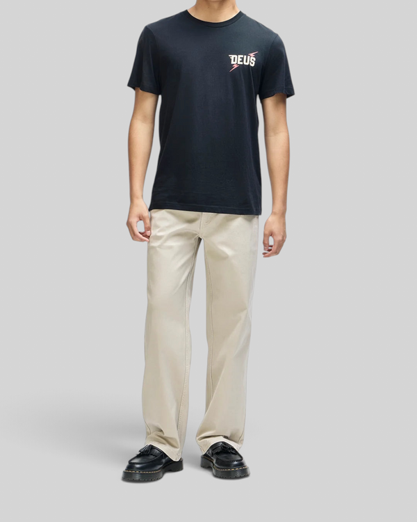 Baffle Haus Global Spark black box fit organic cotton tee with chest graphic worn by a man with beige trousers