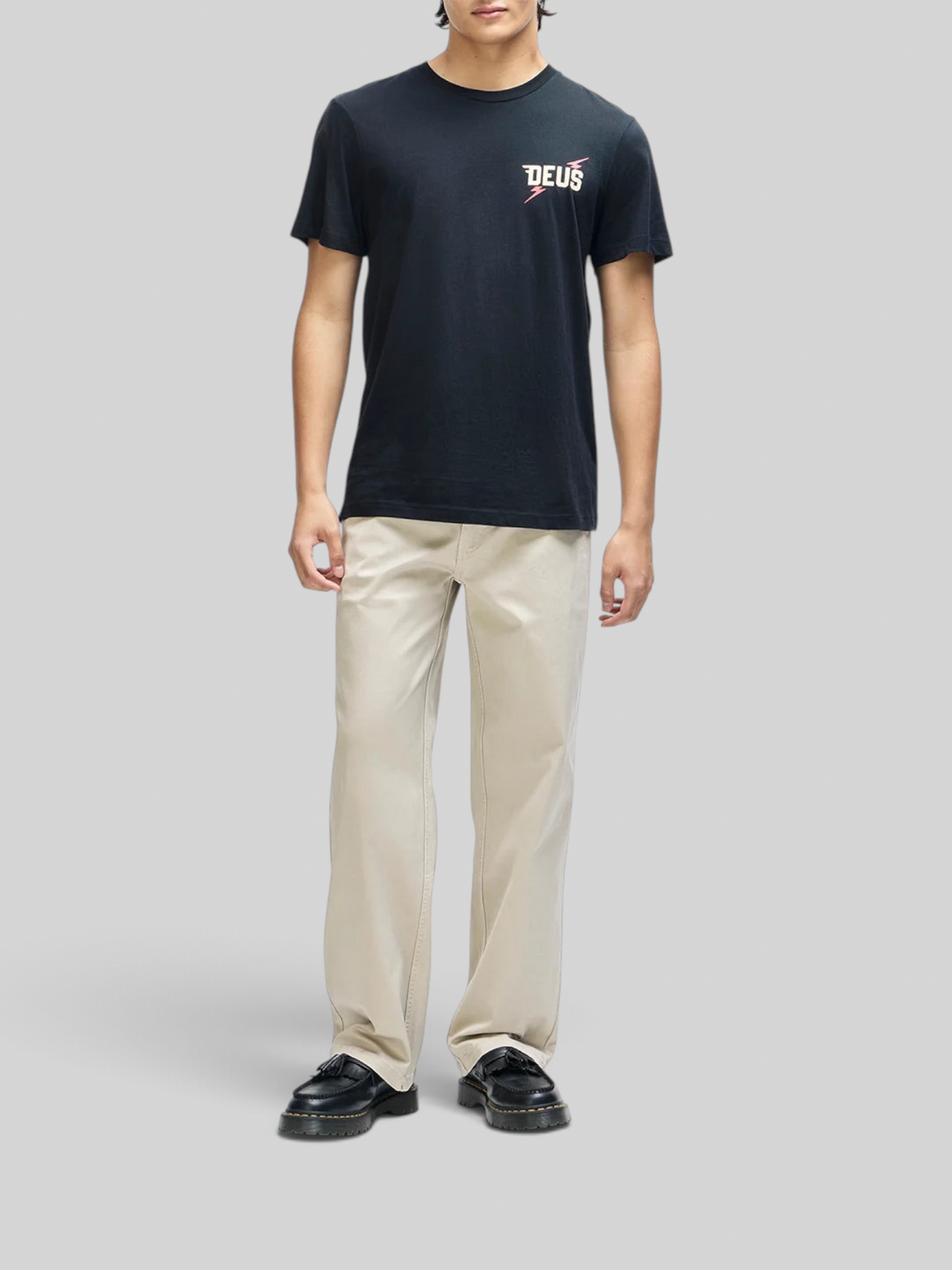 Baffle Haus Global Spark black box fit organic cotton tee with chest graphic worn by a man with beige trousers