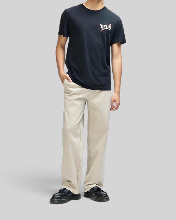 Baffle Haus Global Spark black box fit organic cotton t-shirt with chest graphic worn by a model in beige trousers