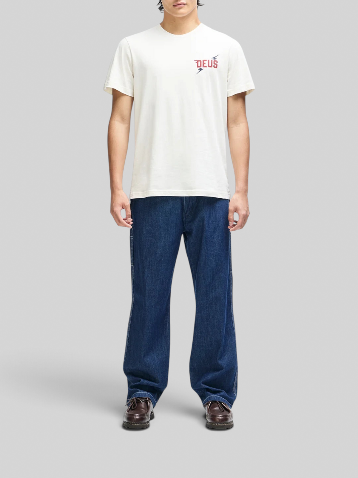 Baffle Haus Global Spark box fit t-shirt in vintage white with chest graphic, worn by a model with blue jeans.
