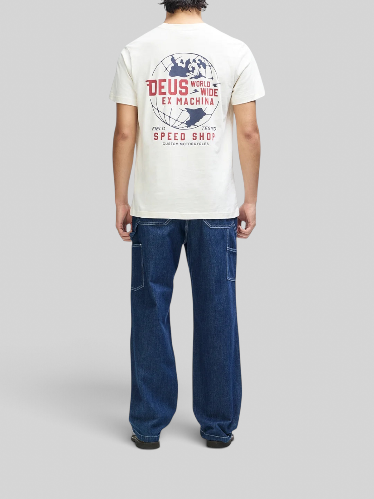 Baffle Haus vintage white box fit t-shirt with graphic globe print on the back, worn with dark blue denim jeans.