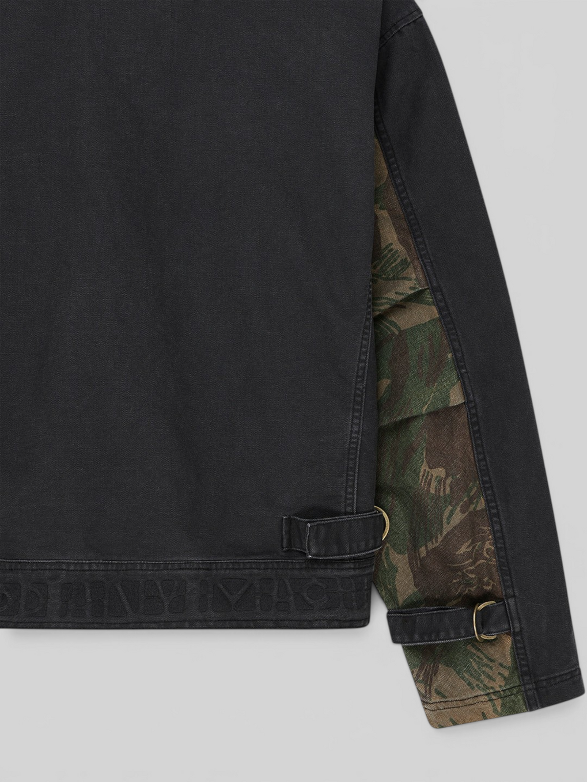 Baffle Haus Common State jacket in overdyed anthracite grey cotton canvas with camo sleeve detail and hem adjustment