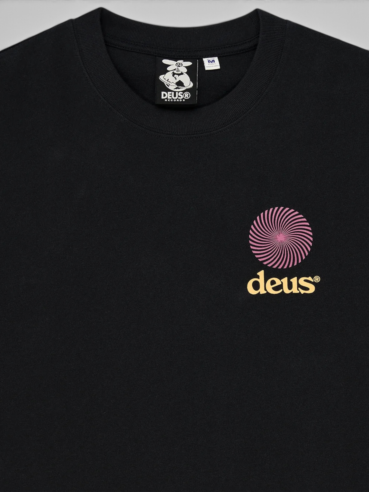 Baffle Haus black oversized recycled cotton t-shirt featuring a pink spiral graphic and yellow logo on the chest