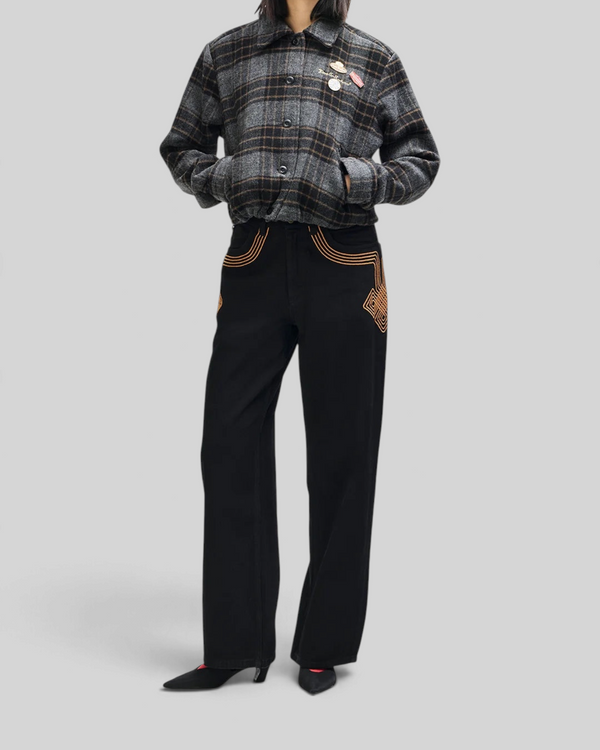 Baffle Haus Lost World wool blend bomber jacket in phantom grey check with custom pins, worn with black trousers.
