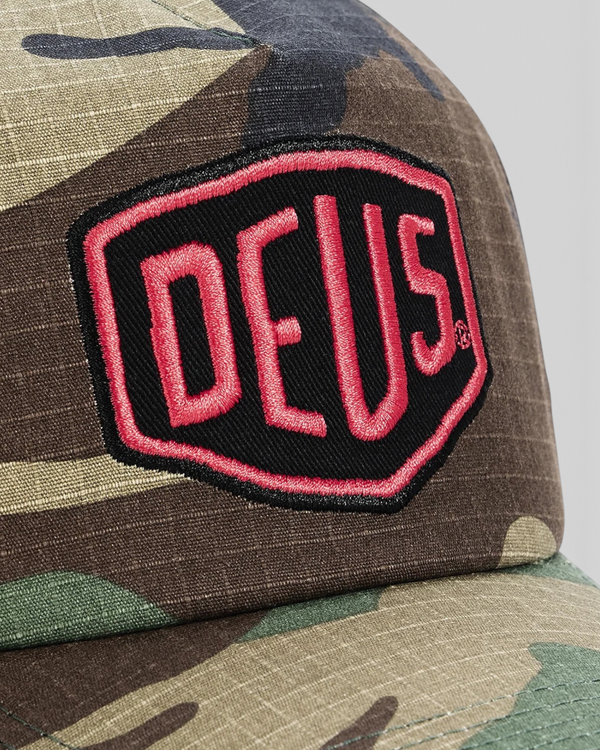 Baffle Haus Paris Shield trucker cap in camo cotton ripstop with a red and black Deus Ex Machina patch