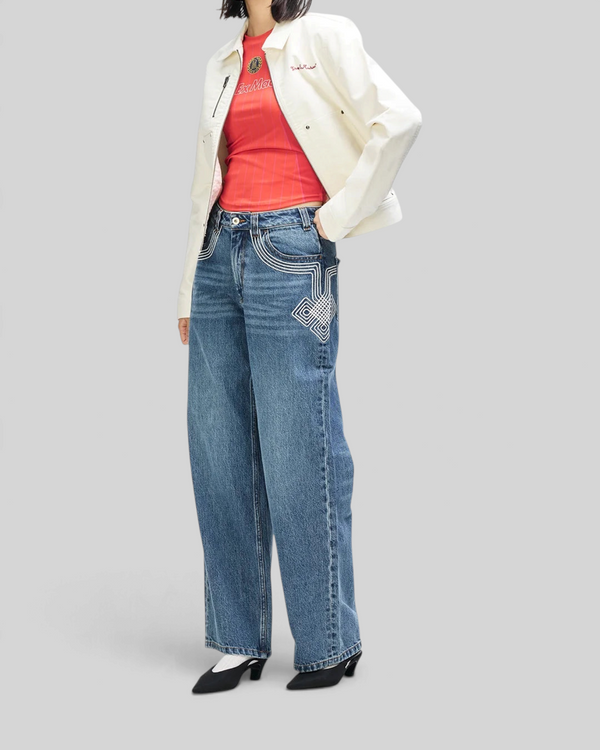 Baffle Haus Trophy Jacket in whisper white cotton moleskin worn over a red top and wide-leg denim jeans