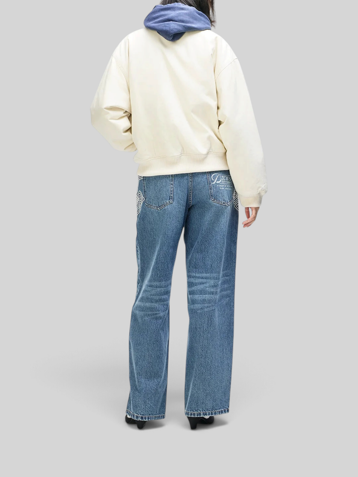 Baffle Haus Runner-Up Jacket in whisper white cotton twill with rib cuffs, worn over blue jeans and a hoodie.