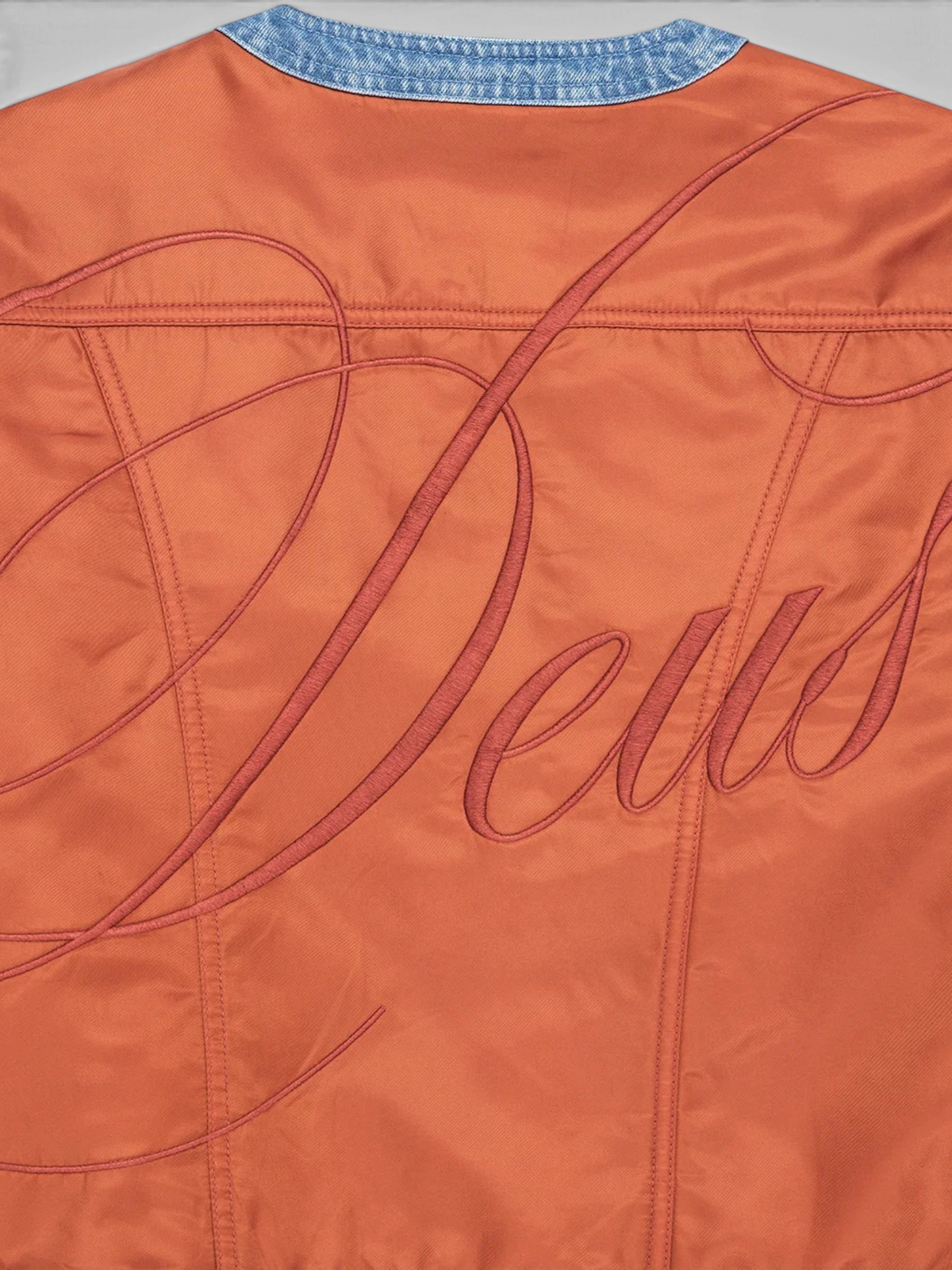 Baffle Haus Br 163 reversible jacket in rust nylon with large Deus embroidery on the back and blue denim collar