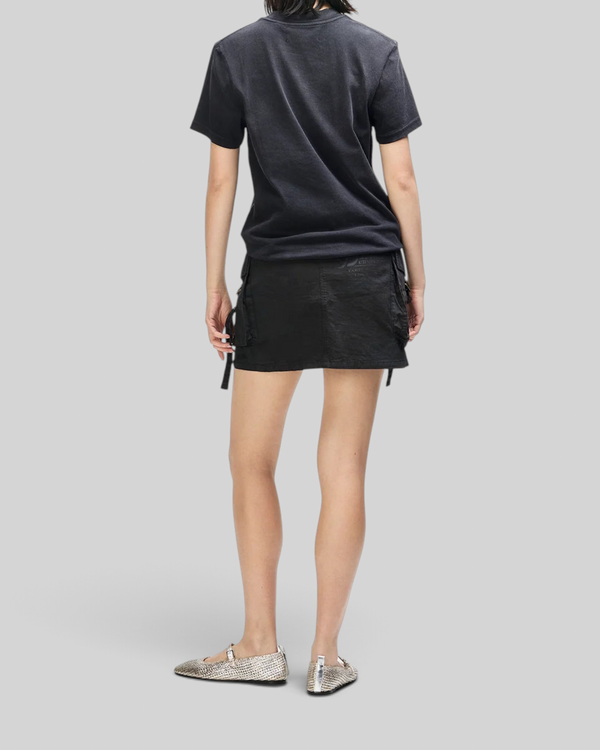 Baffle Haus Daphne Tee in anthracite grey worn with a black utility skirt and metallic flats, back view.