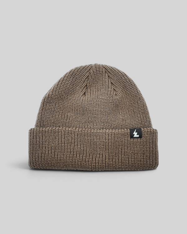 Baffle Haus sand coloured acrylic beanie with a ribbed knit texture and a small woven brand label on the cuff.