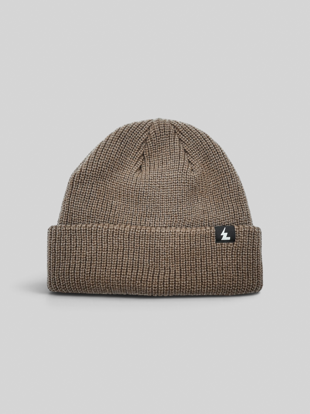 Baffle Haus sand coloured acrylic beanie with a ribbed knit texture and a small woven brand label on the cuff.