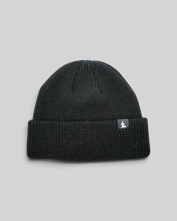 Baffle Haus black acrylic knit beanie with a classic cuffed design and a small woven brand label.