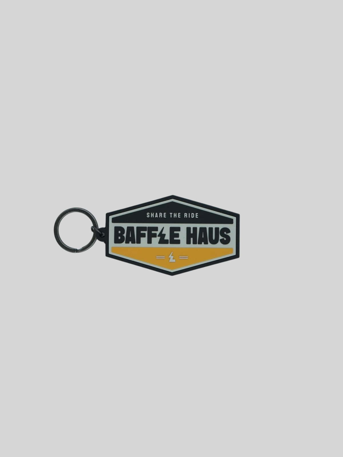 Baffle Haus yellow retro key tag with embossed logo and black split-ring on a light grey background.