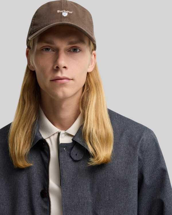 Baffle Haus model wearing an olive green Barbour cotton sports cap with embroidered crest branding