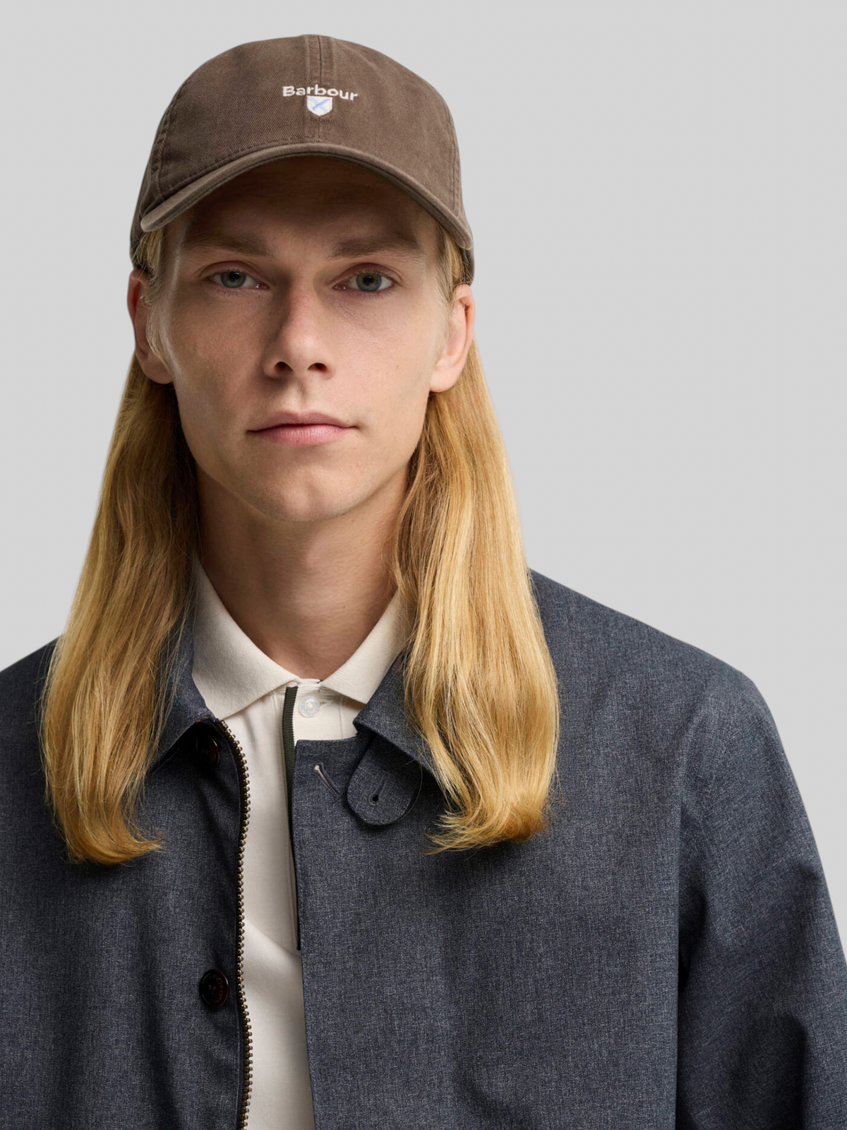 Baffle Haus model wearing an olive green Barbour cotton sports cap with embroidered crest branding