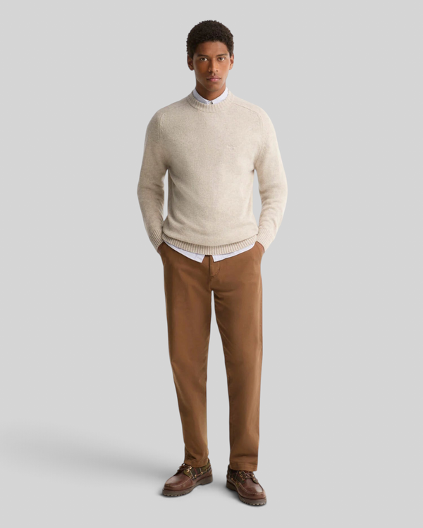 Baffle Haus model wearing a light grey Barbour Newtown lambswool crew neck jumper over a shirt and brown trousers.