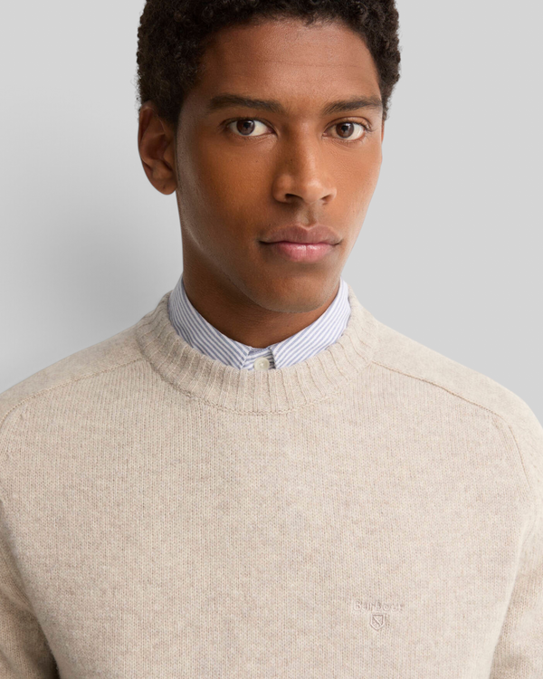 Baffle Haus Barbour light grey lambswool crew neck jumper worn by a man over a striped collared shirt