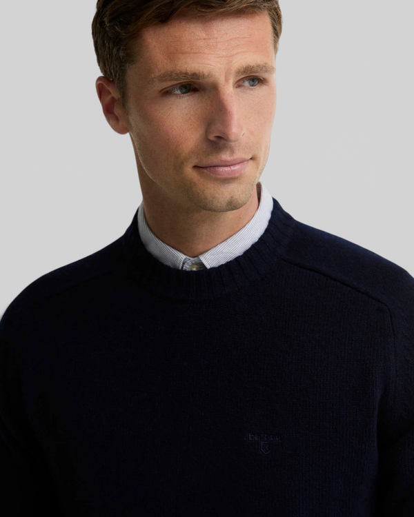 Baffle Haus Barbour Newtown navy lambswool crew neck jumper with ribbed collar and chest embroidery on a male model