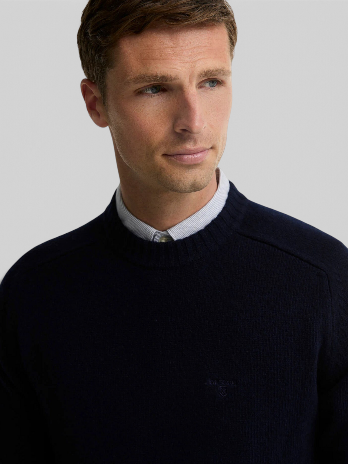 Baffle Haus Barbour Newtown navy lambswool crew neck jumper with ribbed collar and chest embroidery on a male model