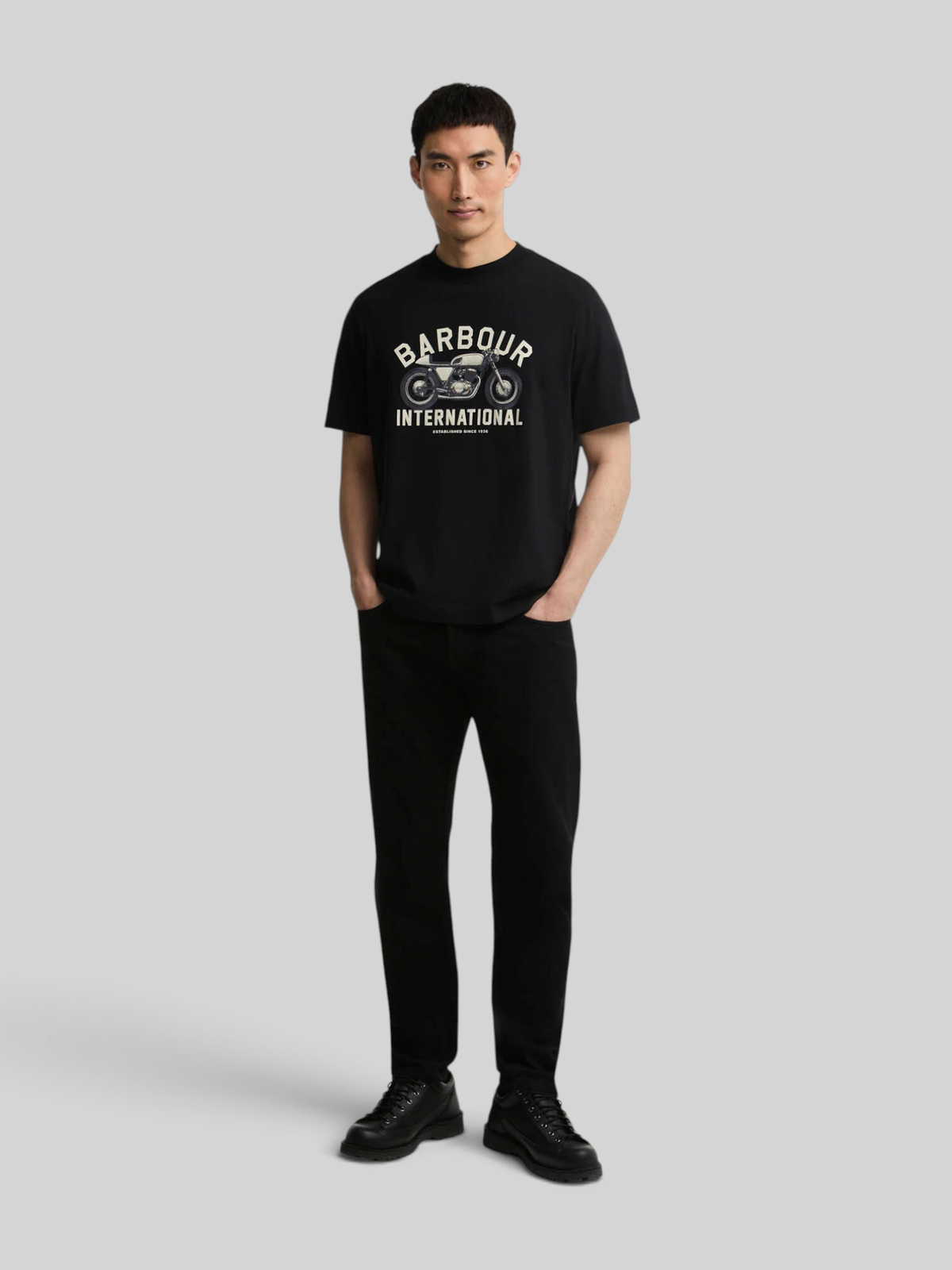 Model wearing Baffle Haus black cotton Eric graphic t-shirt with motorcycle print, relaxed fit and ribbed collar.