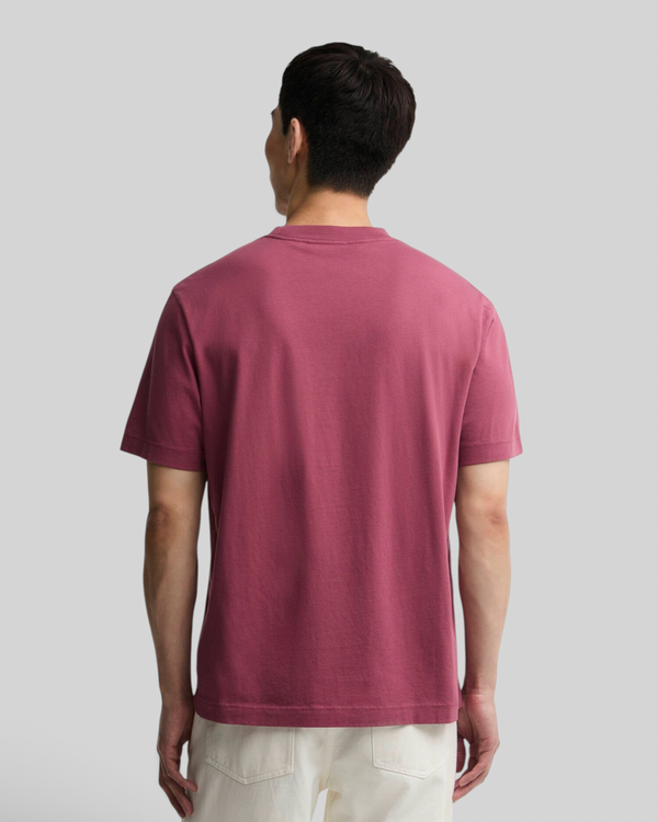Back view of a man wearing a maroon Baffle Haus Eric graphic cotton t-shirt with a relaxed fit.