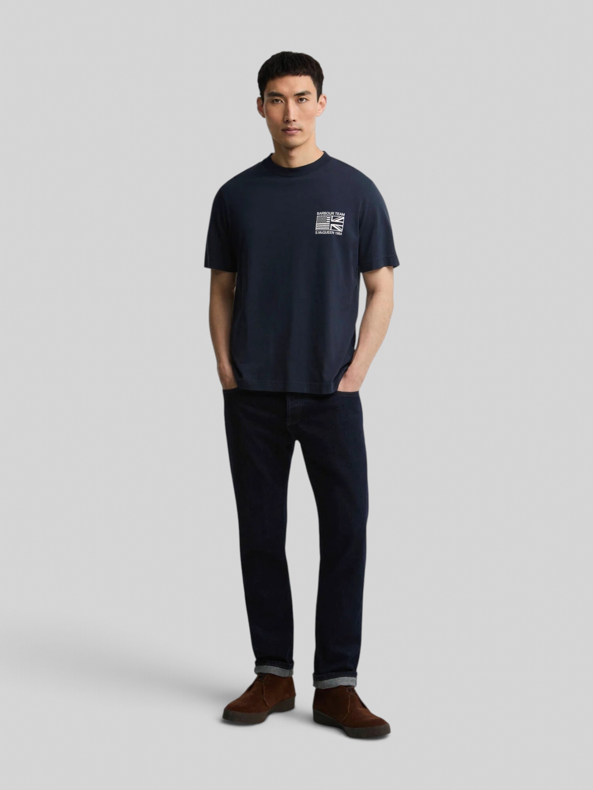 Baffle Haus model wearing a navy blue 100% cotton Steve McQueen graphic t-shirt with a crew neck and open cuffs.