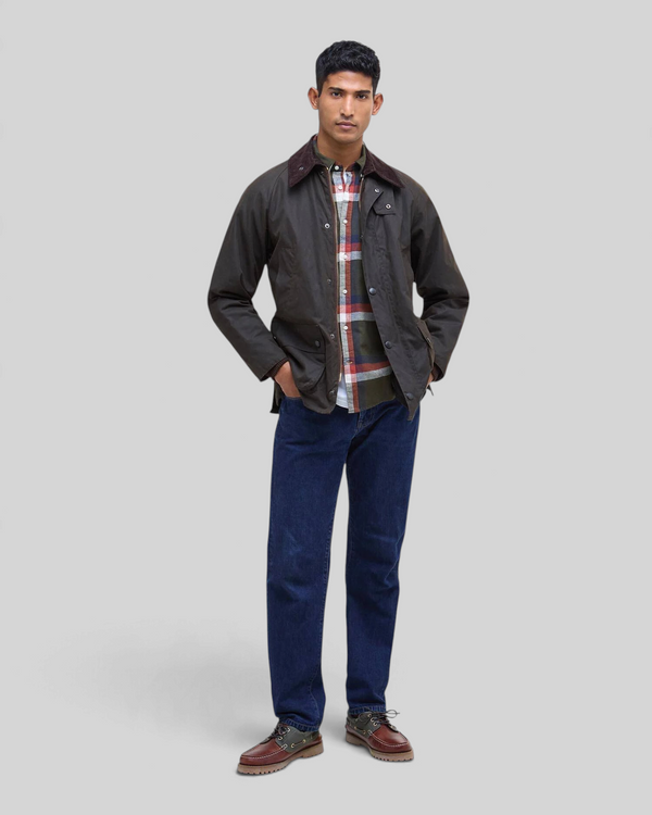 Baffle Haus model wearing an olive Barbour Bedale waxed cotton jacket with a corduroy collar and tartan lining.