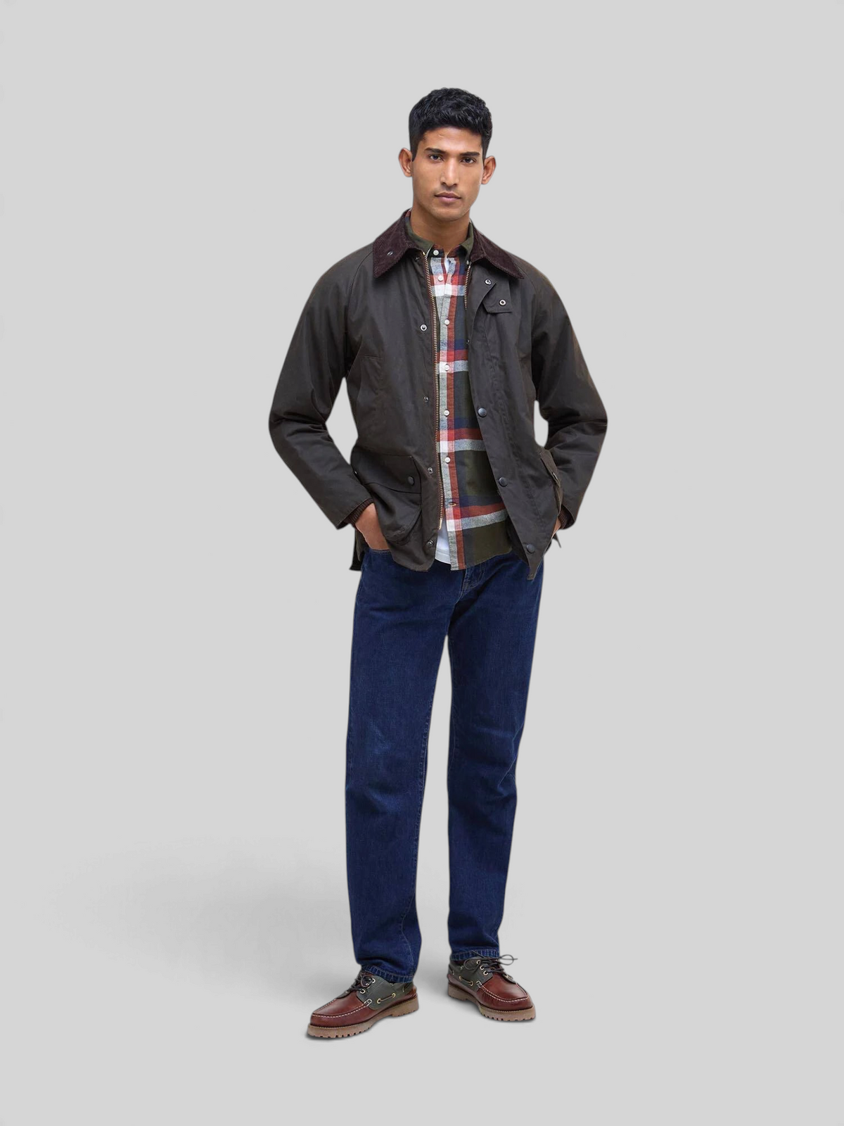 Baffle Haus model wearing an olive Barbour Bedale waxed cotton jacket with a corduroy collar and tartan lining.