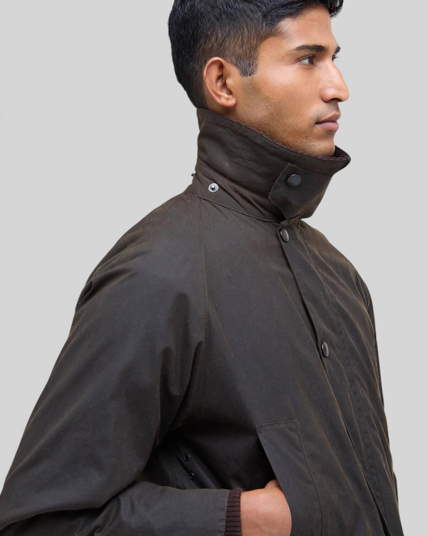 Baffle Haus Bedale olive waxed cotton jacket with corduroy collar worn by a man in profile view