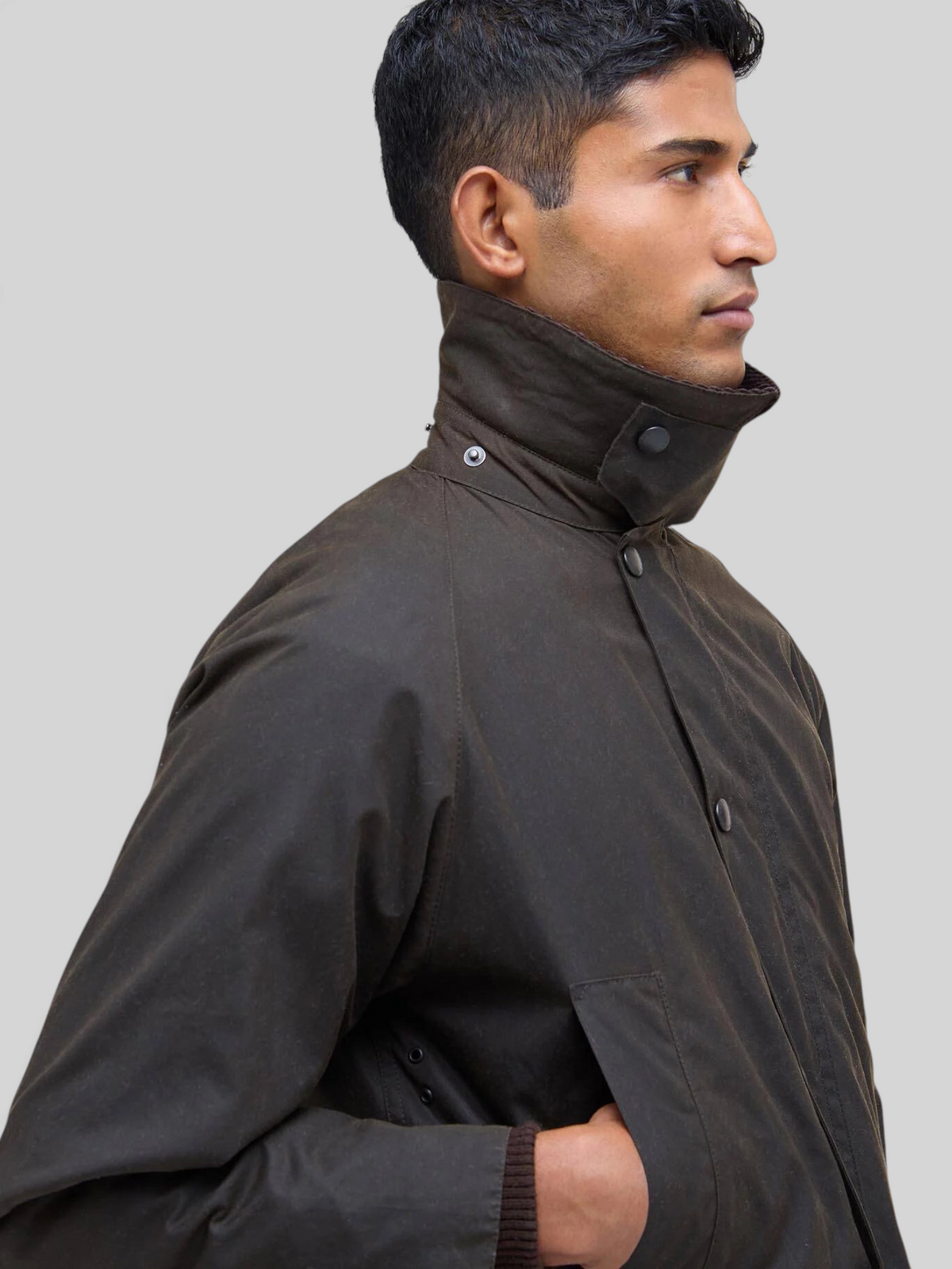 Baffle Haus Bedale olive waxed cotton jacket with corduroy collar worn by a man in profile view