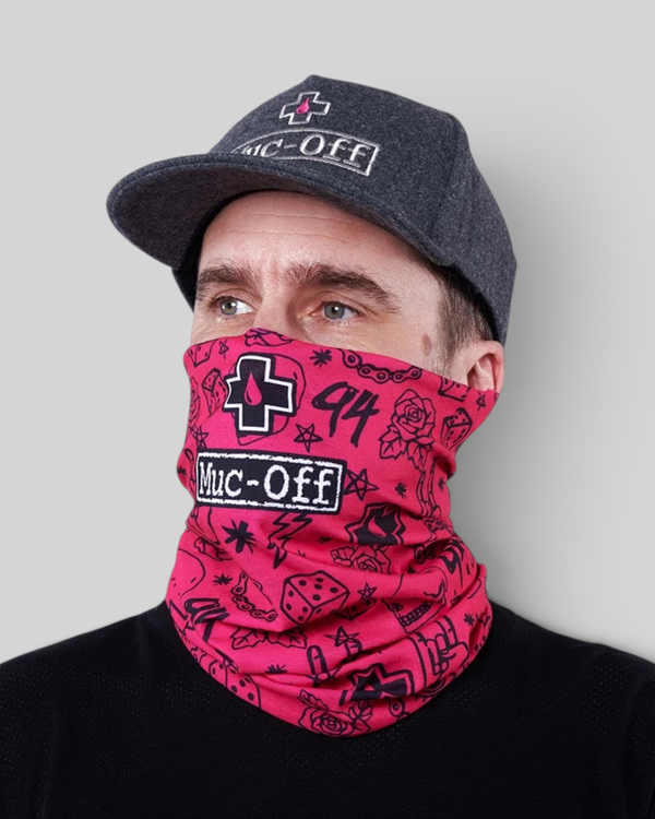 Baffle Haus pink neck tube with punk-inspired black graphic print worn by a man in a grey cap