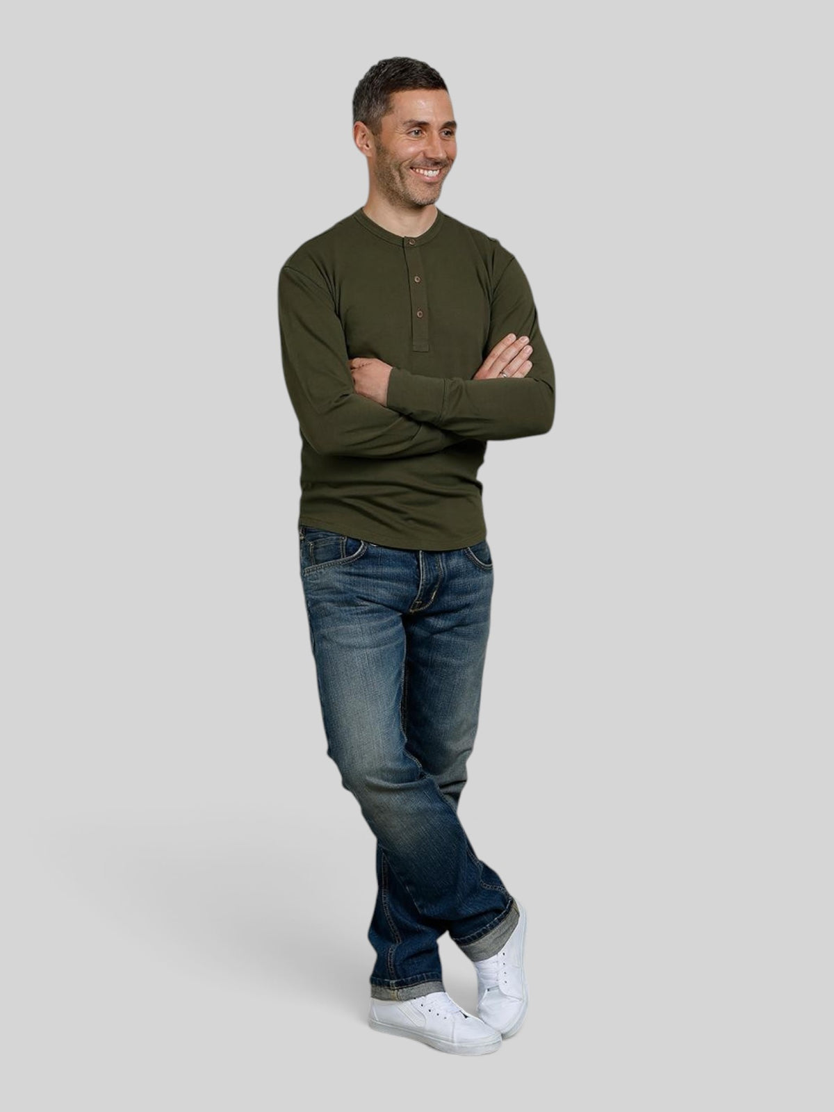 Baffle Haus 1927 Henley long sleeve shirt in Mojave green cotton with coconut buttons worn by a smiling man