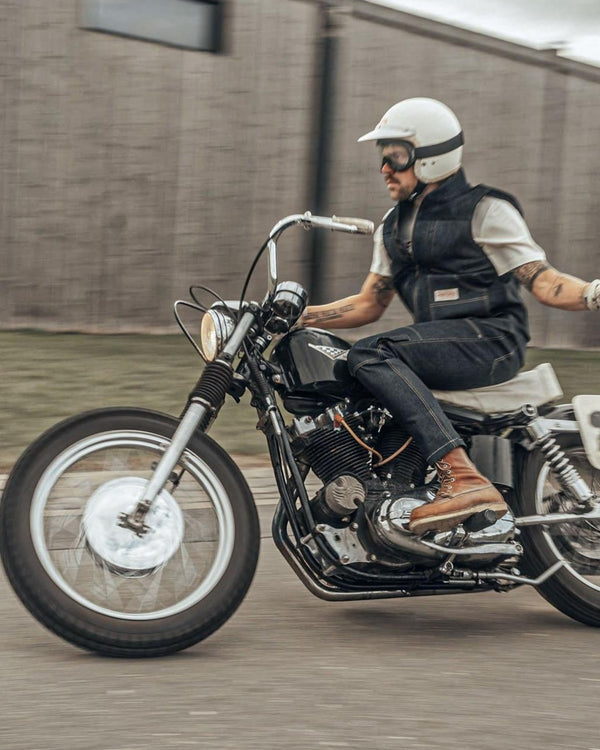 Baffle Haus Age of Glory Crafter Gloves in aged white worn by a motorcyclist riding a vintage bike on a road
